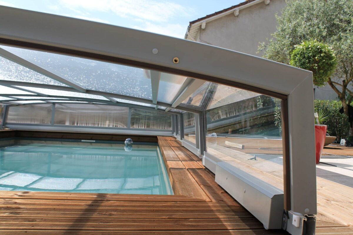 Piscina cubierta con una estructura alta de policarbonato celular, permitiendo el baño en un día nublado.