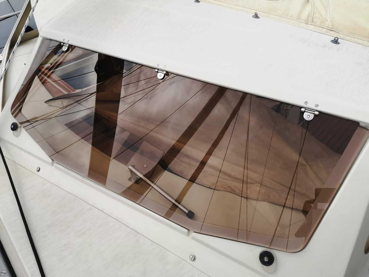 Primer plano de una ventana de policarbonato instalada en un barco, mostrando su claridad y robustez.