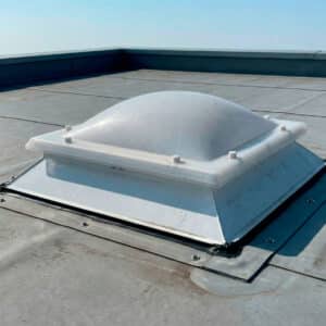 Techo exterior con placa de policarbonato blanca tipo claraboya bivalva, montada sobre superficie gris de cemento.