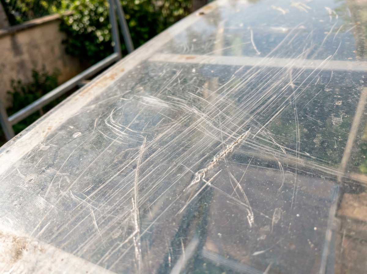 Detalle de superficie de policarbonato mostrando sensibilidad a rayaduras en cubierta exterior